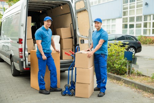 Professional movers carrying furniture in a Surrey home